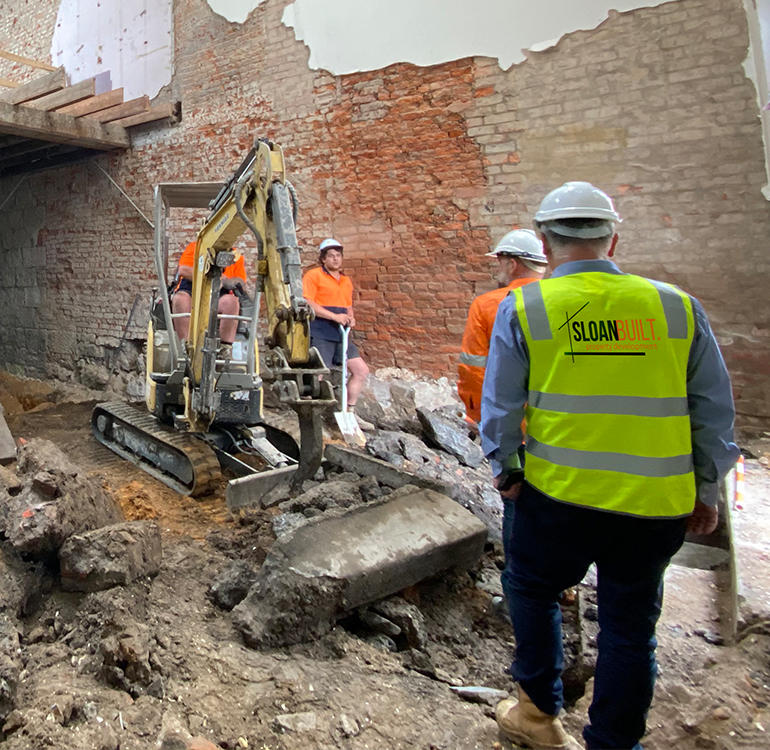 Construction workers on site inspecting building works.